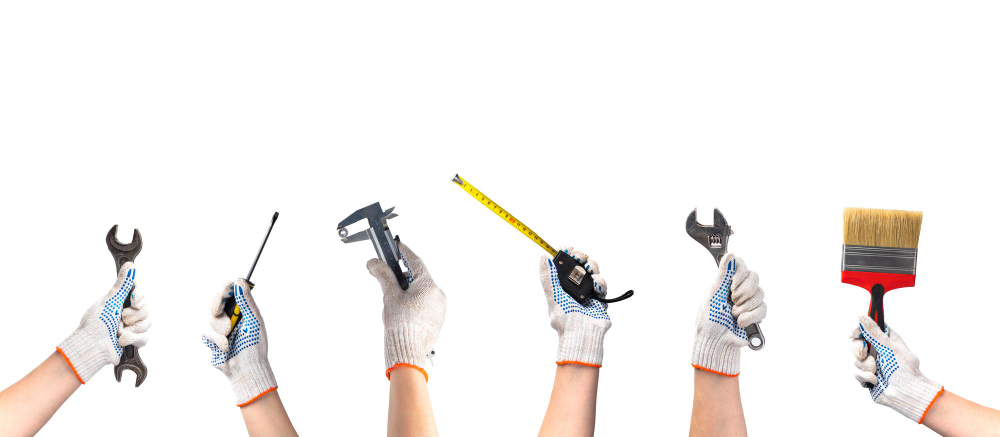 hands holding various handyman tools on a white background