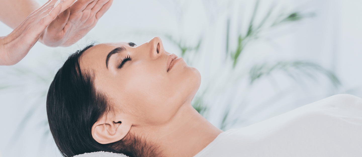 A woman receiving a Reiki session.