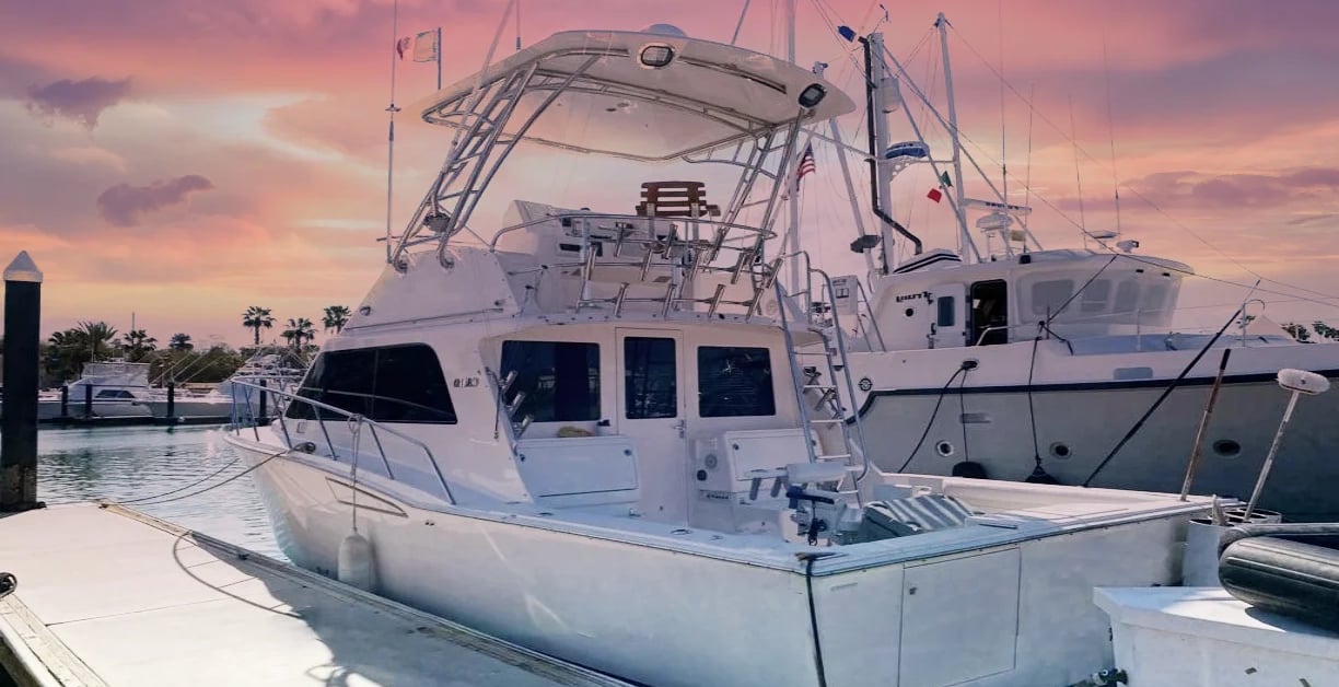 a boat docked at a dock with a pink sky