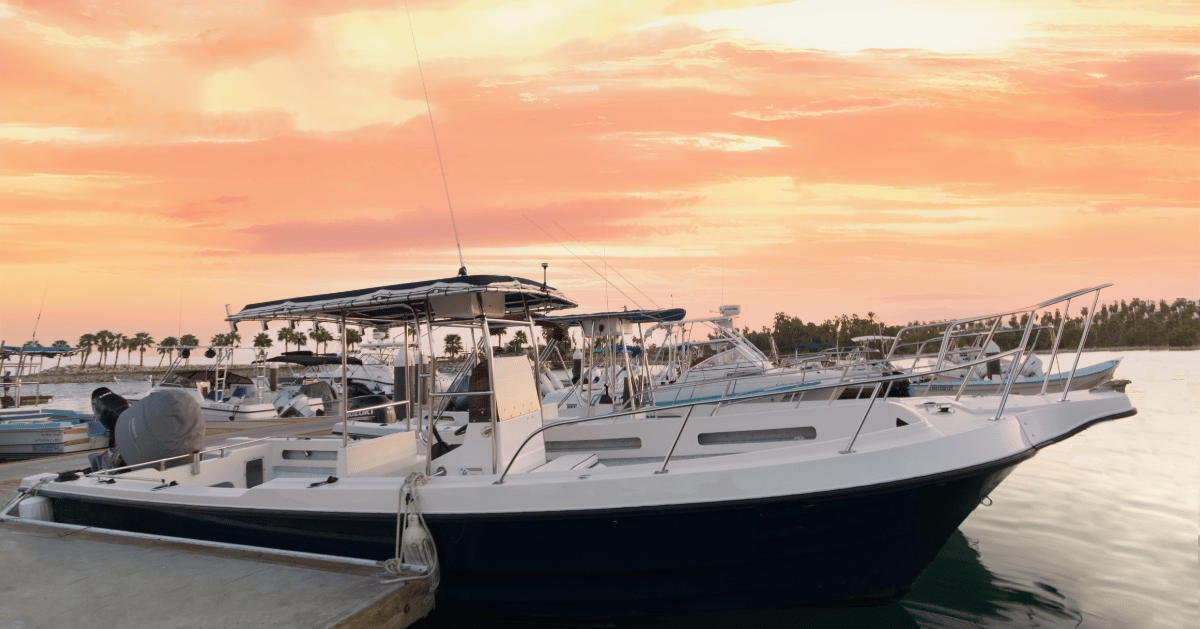 a boat docked at a dock with a man standing next to it