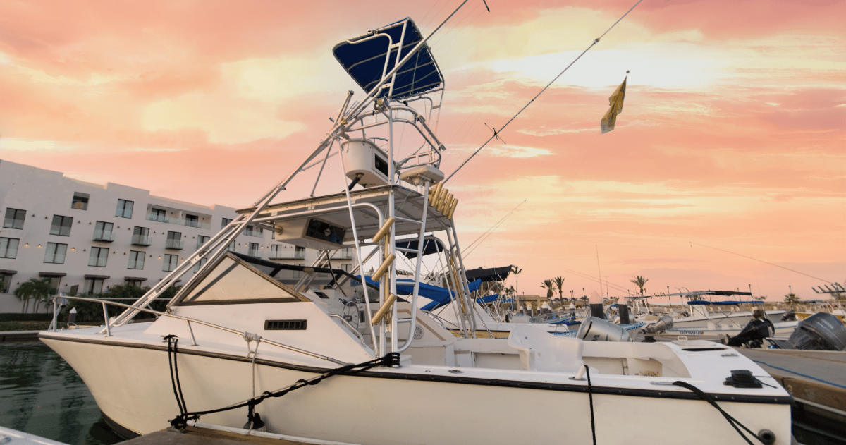 a boat docked at a marina with a pink sky