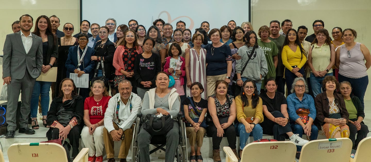 Un grupo diverso de personas posando para una foto de reunión comunitaria en una sala de conferencia