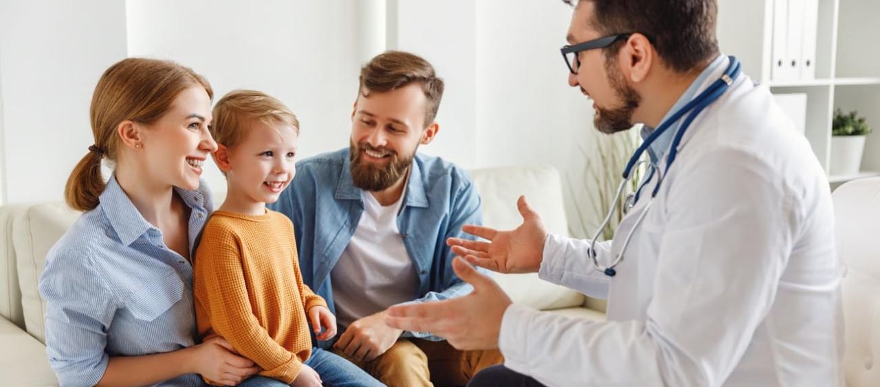 a doctor talking to a child in a living room martin pe / coach