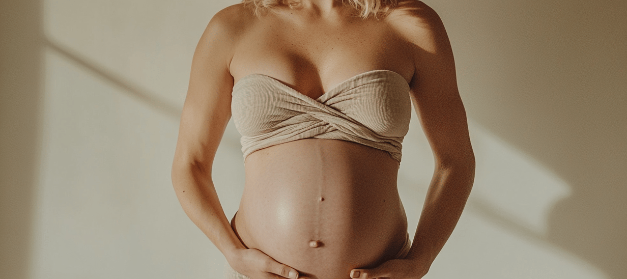 Fotografía de una mujer embarazada usando un top y tocando su vientre