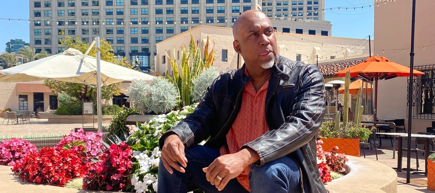Lee A Jones sitting on a concrete bench in front of a building