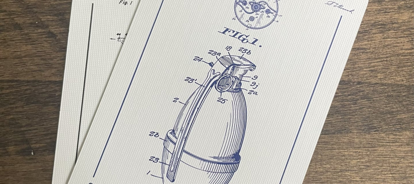 Two playing cards faced up. A close up view of a blue grenade engineering drawing is shown