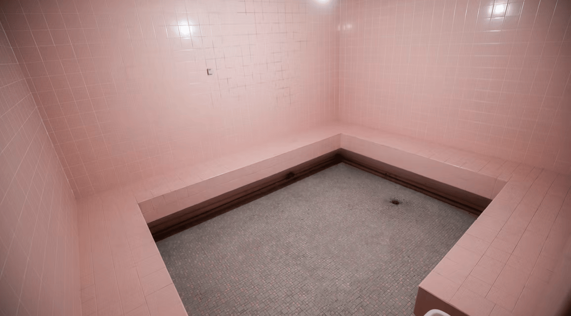 Pink sauna room set at Grayfox Studios featuring tiled walls, cozy lighting, and vibrant aesthetic