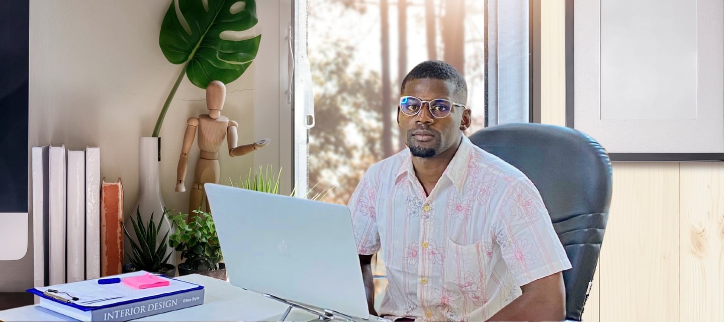 a man sitting at a desk with a laptop computer