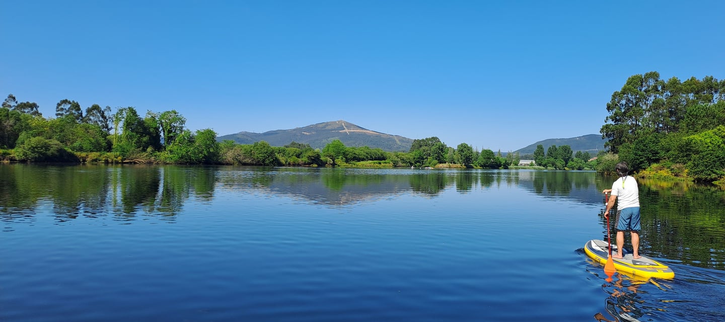 Chico remando en el río ulla sobre una tabla de paddle surf
