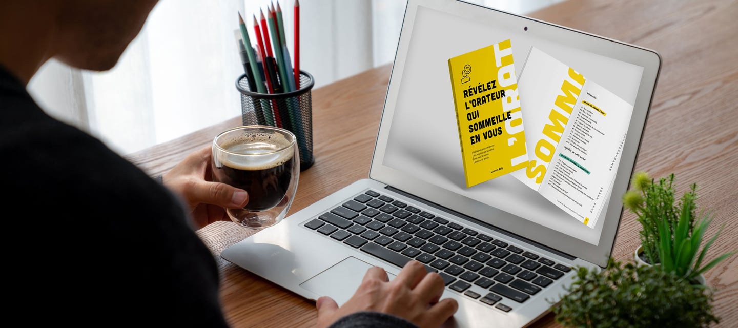 Entrepreneur consultant sur son ordinateur le livre "Révélez l'orateur qui sommeille en vous"