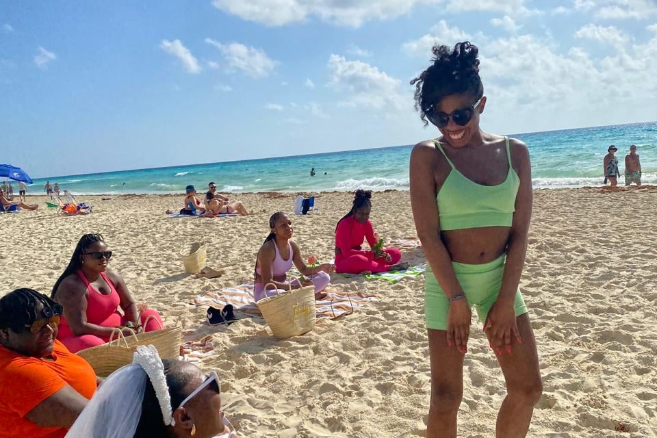 a woman in a green bikinisuit on a beach in Playa del carmen after yoga with erinb