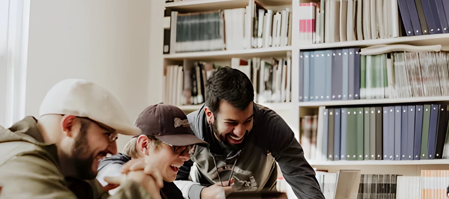Three men in a library engaged in a discussion about studying abroad