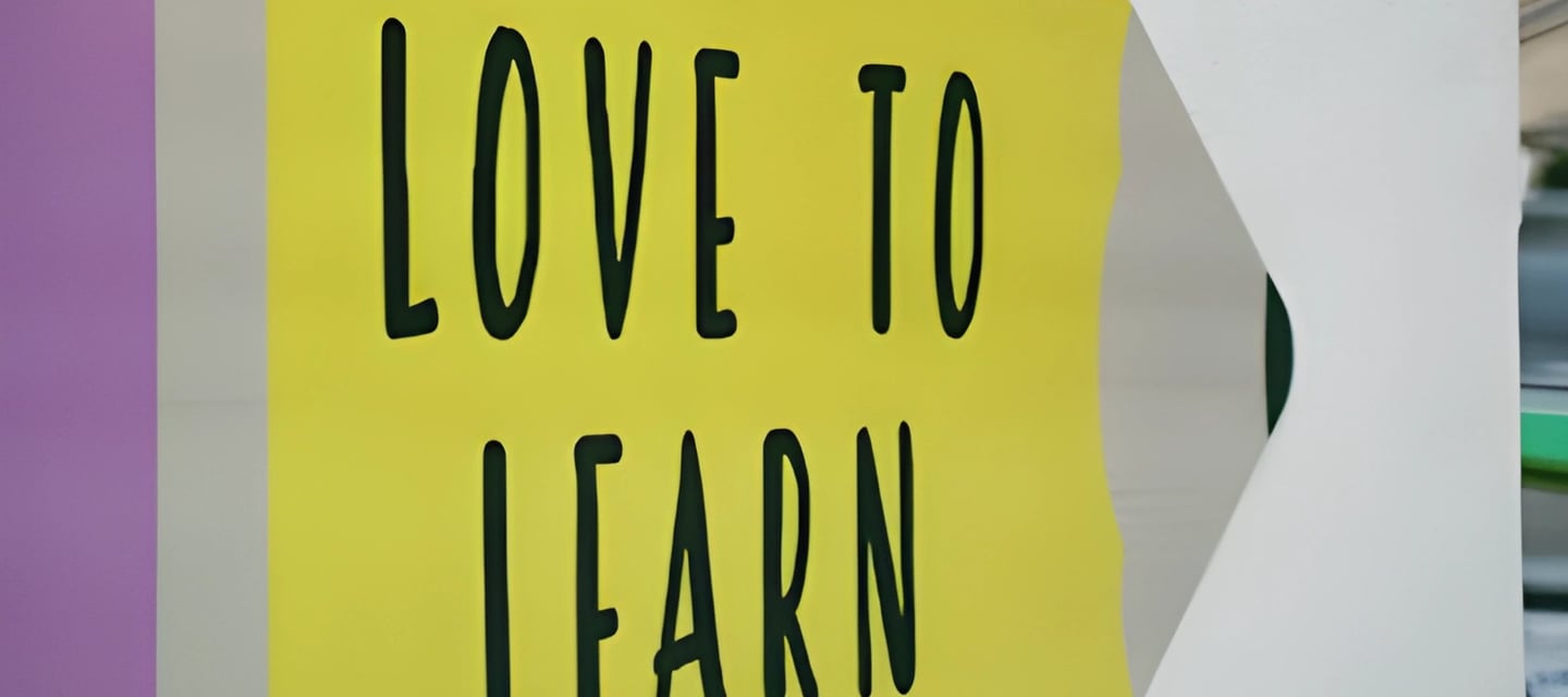 Colorful sign with a stylized pencil shape and 'LOVE TO LEARN', reflecting Admit 360