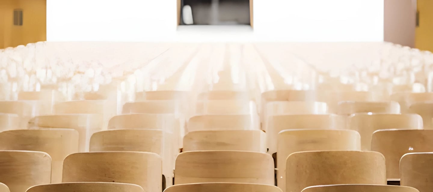 Wooden chairs facing a stage indicating a formal event, reflecting Admit 360's strategic guidance