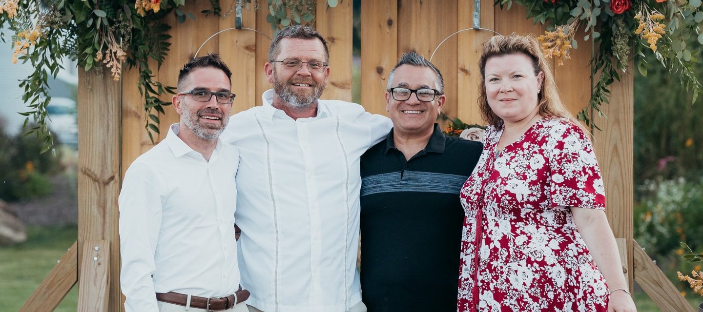 a family posing for a photo in front of a wooden door