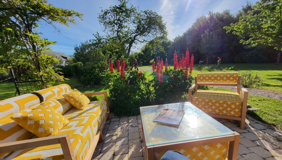 Terrasse ensoleillée avec un salon de jardin aux tissus à motifs texturé