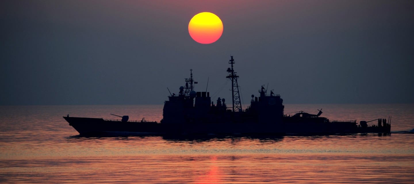 a boat in the water with a sunset in the background
