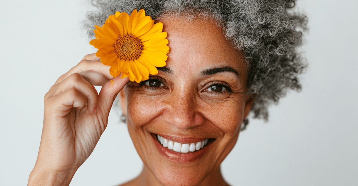 Mujer mayor con afro canoso colocando una flor amarilla en su frente 