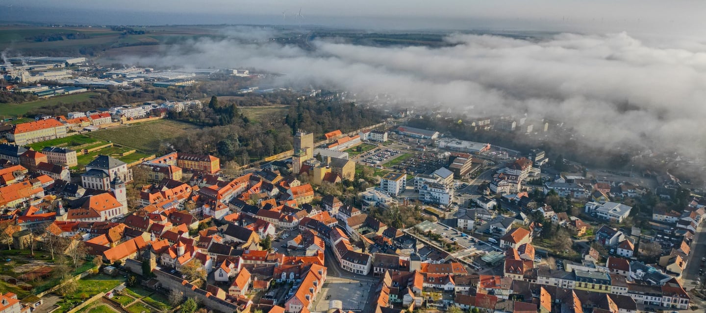 Luftbild der kleinen Residenz Kirchheimbolanden mit der Altstadt im Fokus und Teile im Nebel