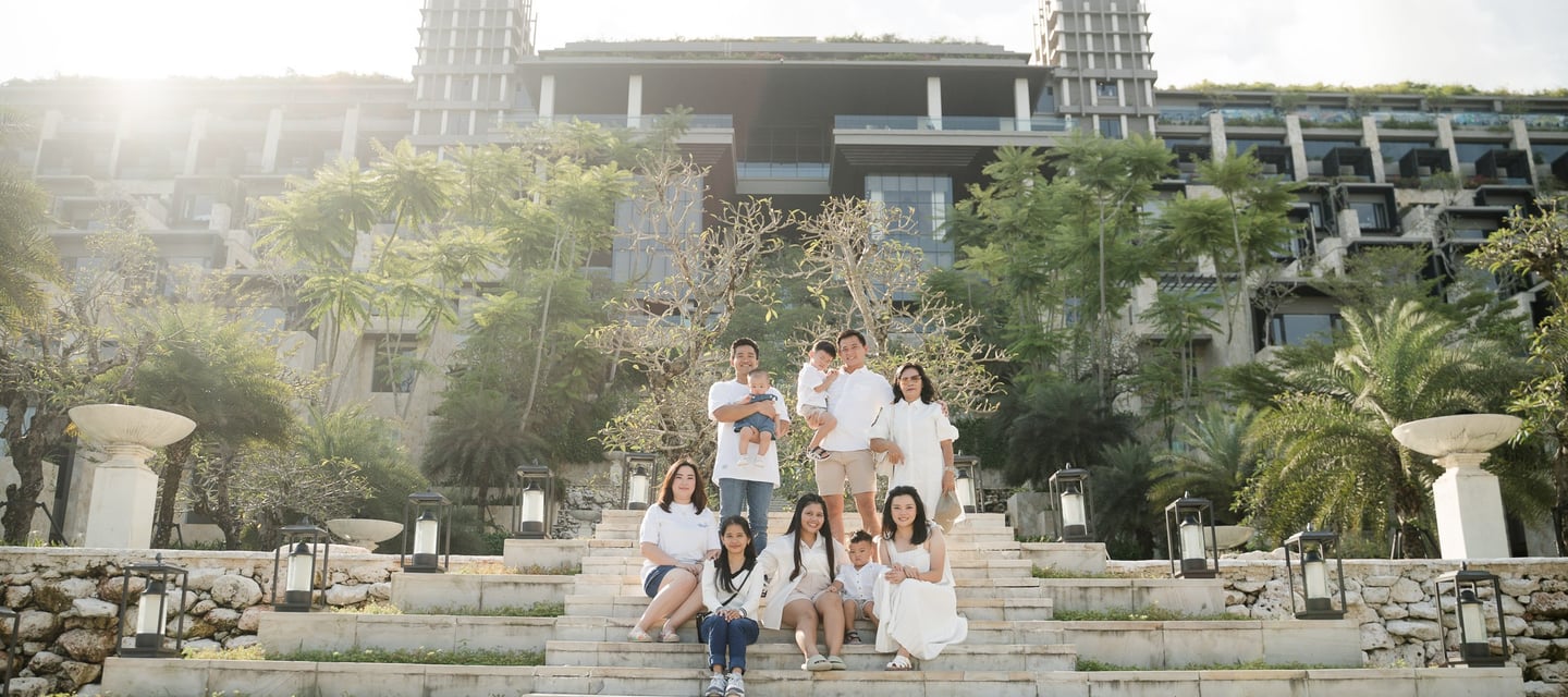Large family walking down the iconic staircase at The Apurva Kempinski Nusa Dua during a Bali family photography session