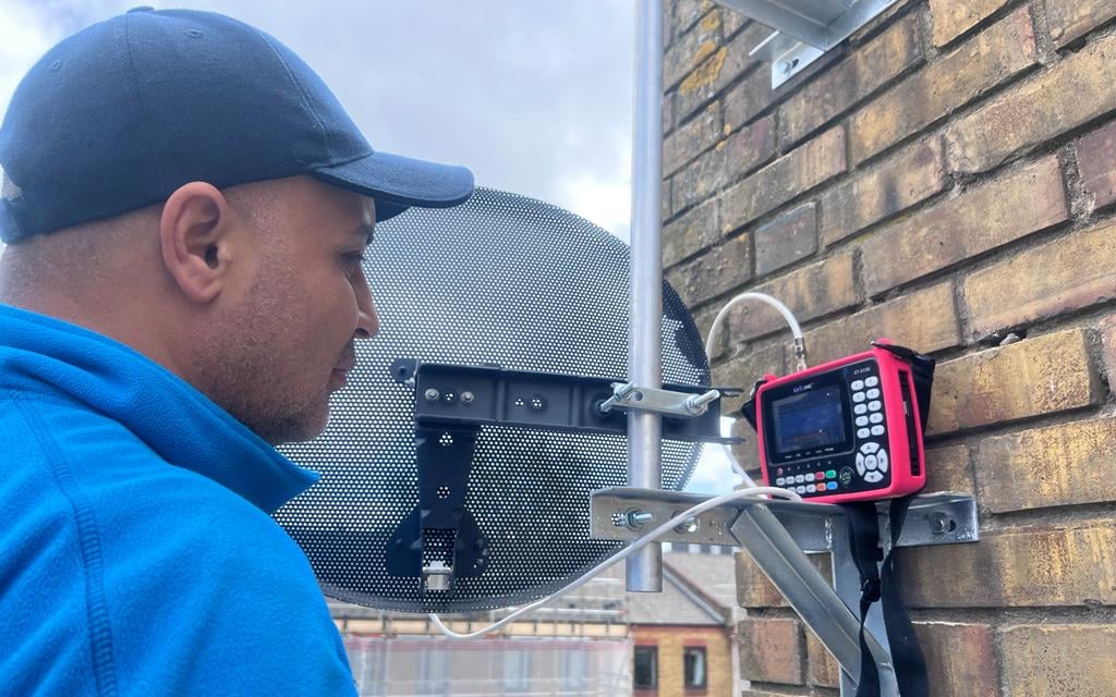 Man installing sky dish and antenna in one tube bar