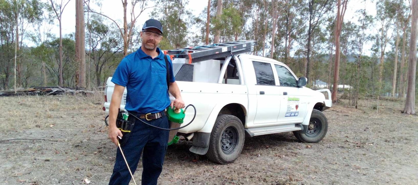 pest control technician standing in front of pest vehicle