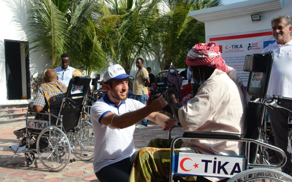 Somali men with disabilities supported by Turkish aid organization cooperating with Taraahamo, emphasizing solidarity and ass
