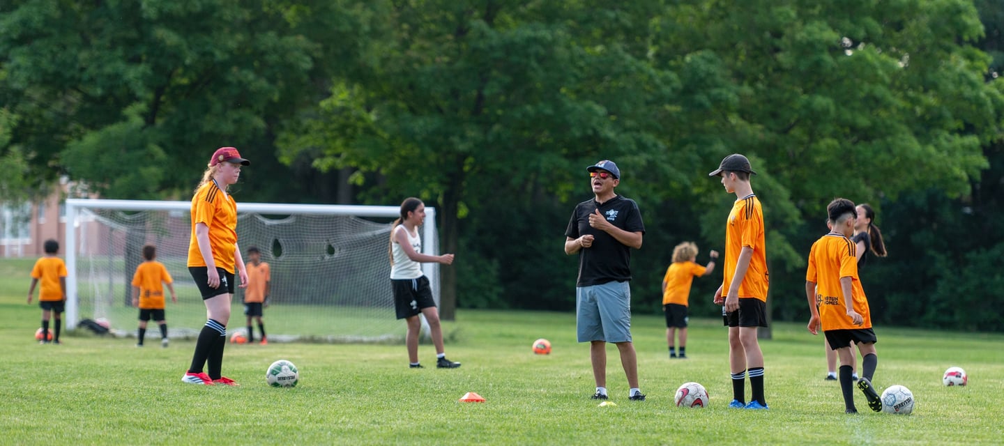 A MVB FC soccer coach instructs youth player In Mississaugas