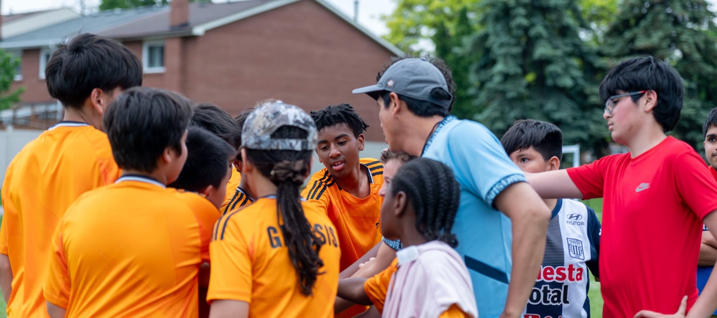 MVB F.C. soccer players gathers in a huddle with their coach In Mississauga Ontario