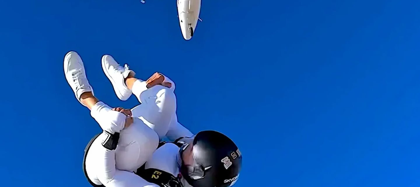 mais alhajri skydiving in white jumpsuit after exiting a plane