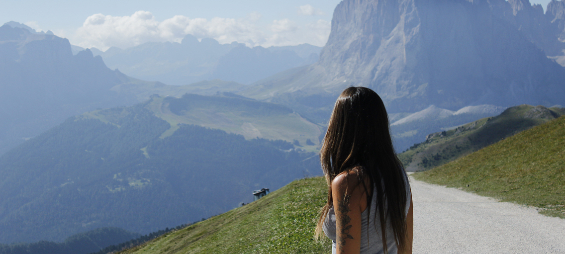 Magui fotografiada de espaldas viendo una montaña soleada