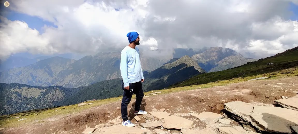 Clouds casting playful shadows on Himalayan mountains, Uttarakhand, serene alpine landscape.