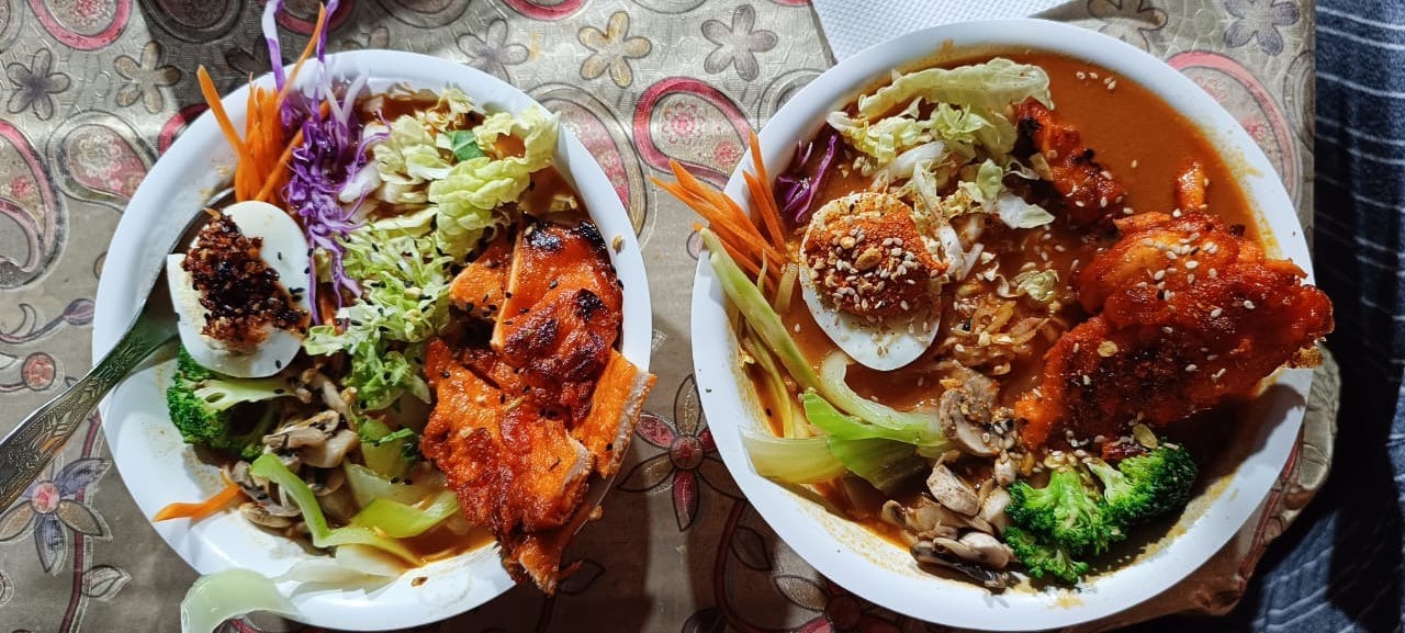 Street-style ramen bowl with creamy chicken and a spicy miso broth, offering a satisfying and flavor
