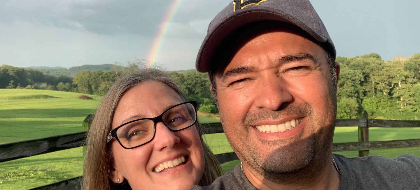 husband and wife taking a selfie on our lavender farm with rainbow - colored rainbows