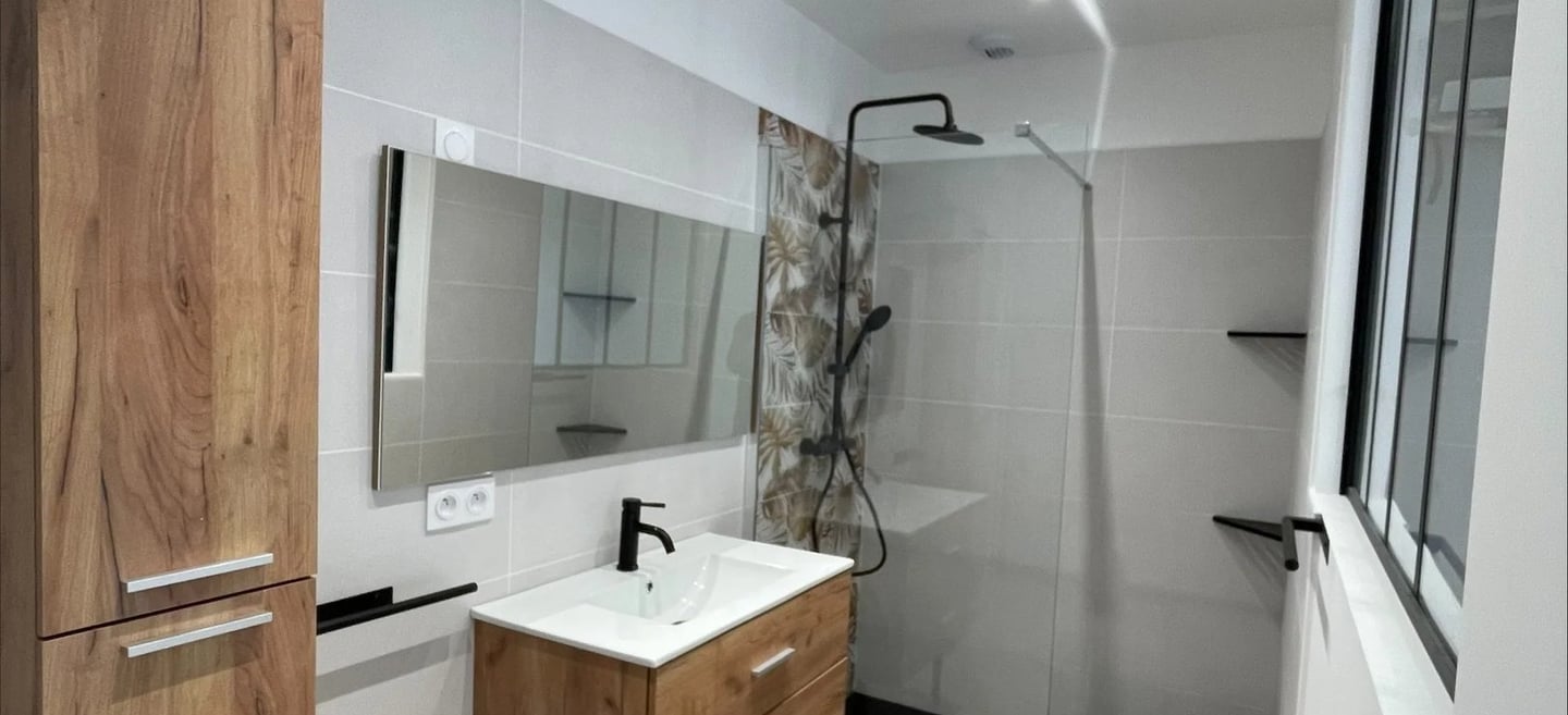 Salle de bain : meuble bois, douche à l'italienne et grand miroir minimaliste.