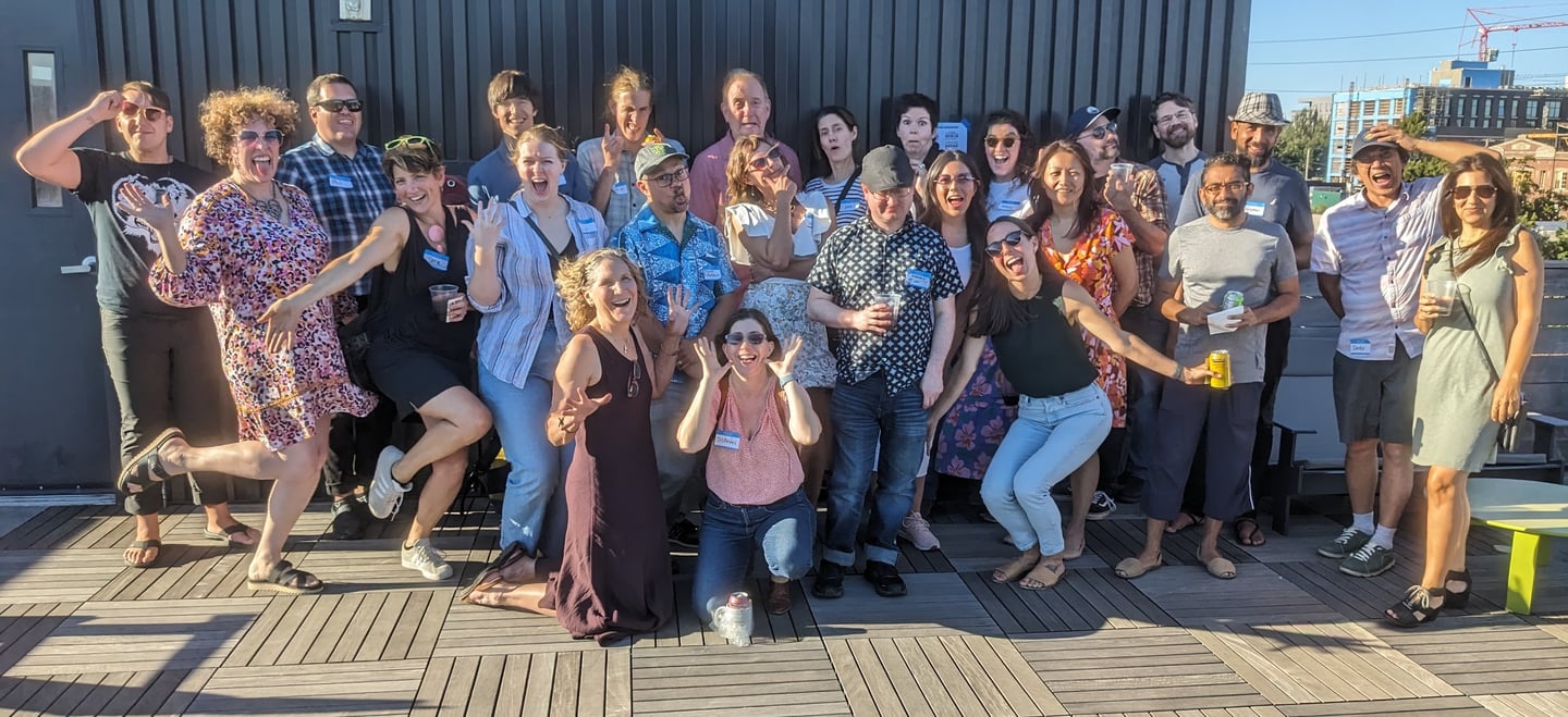 a group of people at the Portland Design Thinkers rooftop happy hour, posing and making silly faces