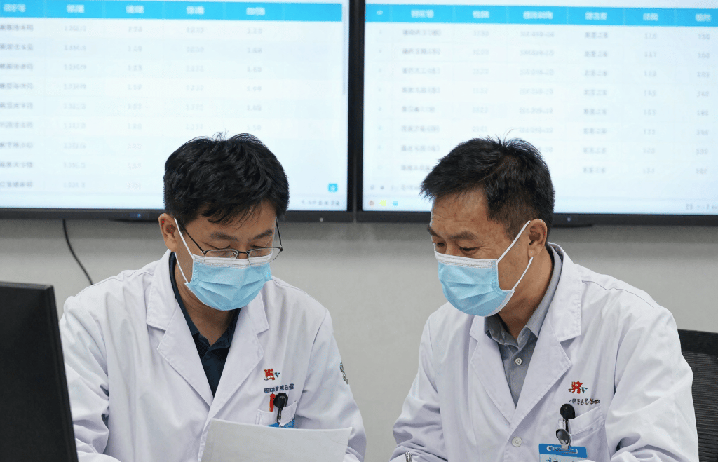 Modern laboratory setting with scientists collaborating over biomarker data on computer screens.