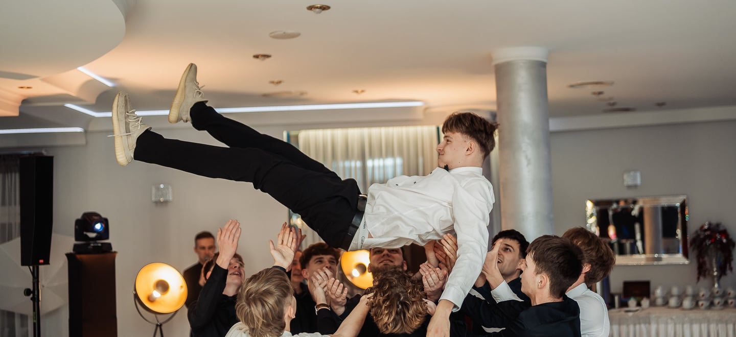 a man is doing a trick on a man in a suit and tie