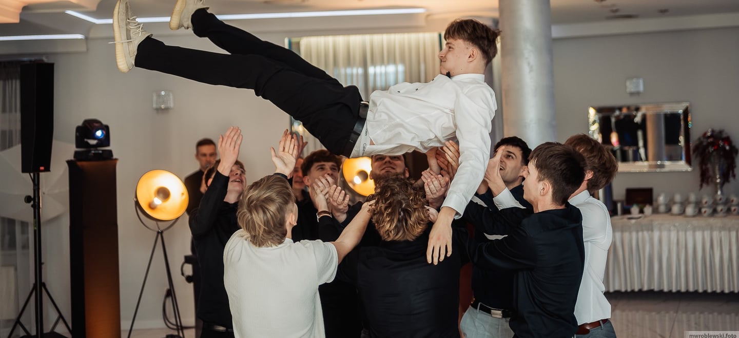 a man is doing a trick on a man in a suit and tie