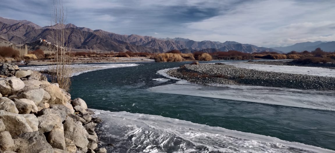 a river with ice and snow on the ground