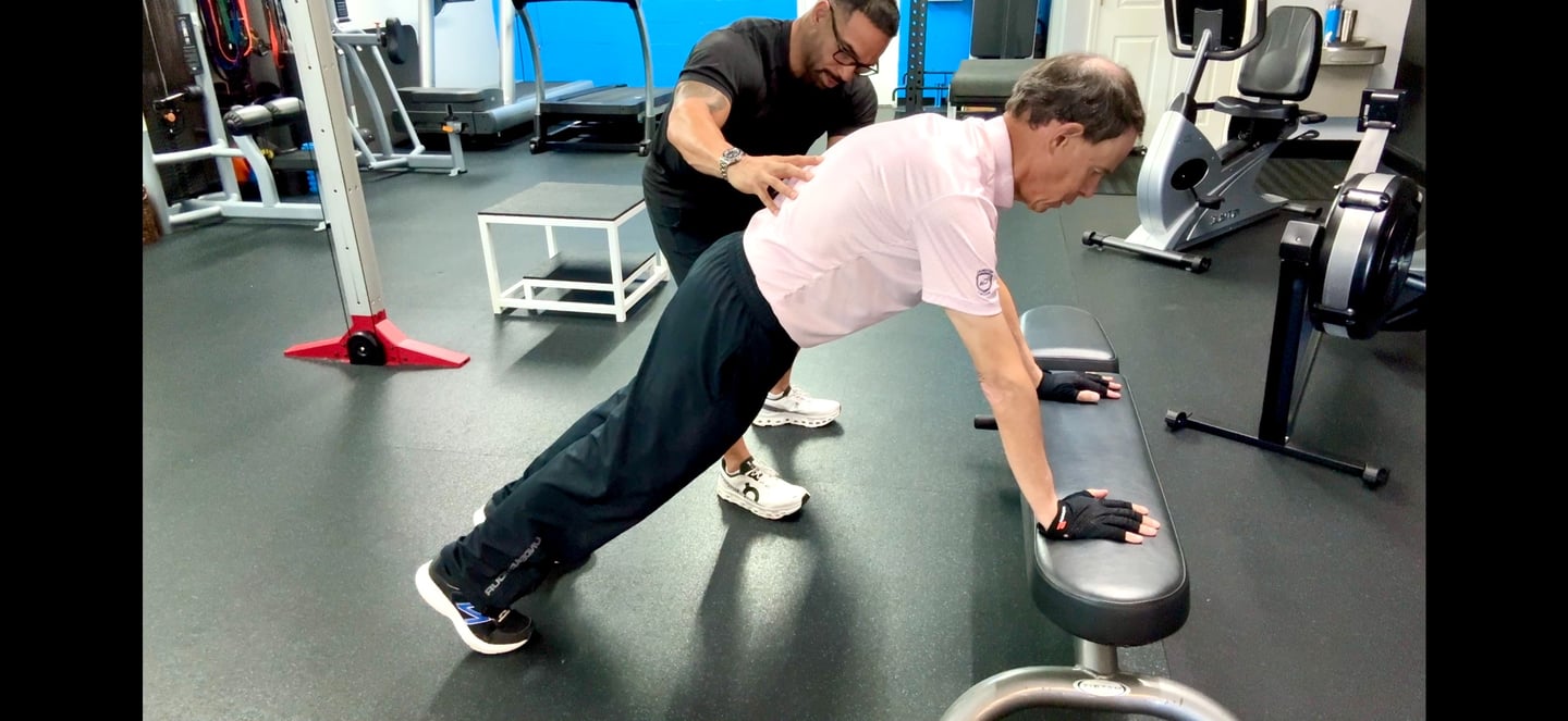 fitness coach helping man with push up form