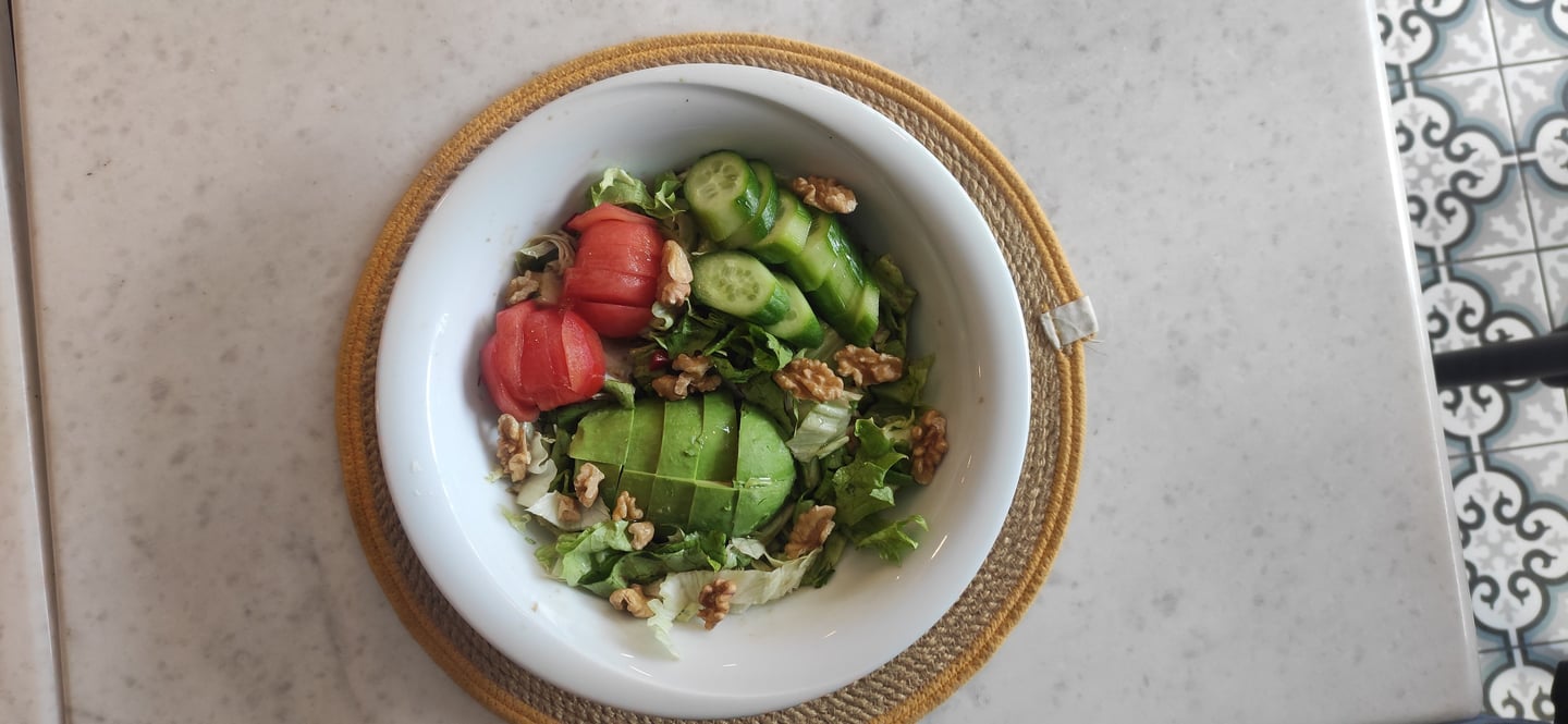 yeşillikle ve domates ve avakado olan salata kasesi