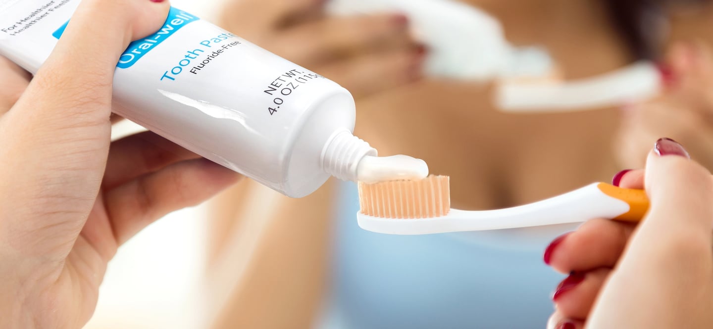 a woman is holding a toothbrush and toothbrush in her hand