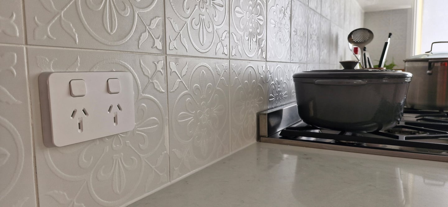a white power point above a bench in a kitchen