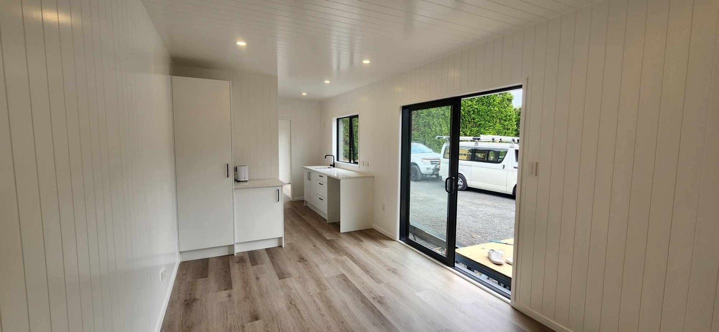 View of kitchen cupboard and sliding door of tiny home