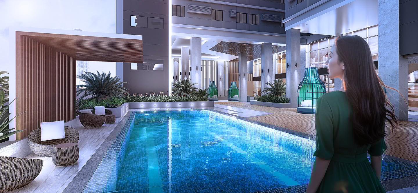 a woman in a green dress standing in front of a swimming pool