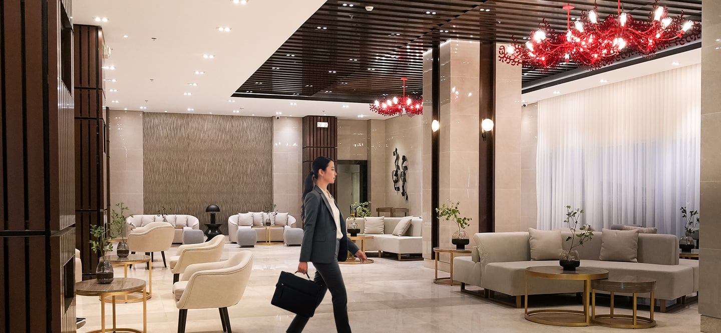 a woman walking through a lobby area of a hotel