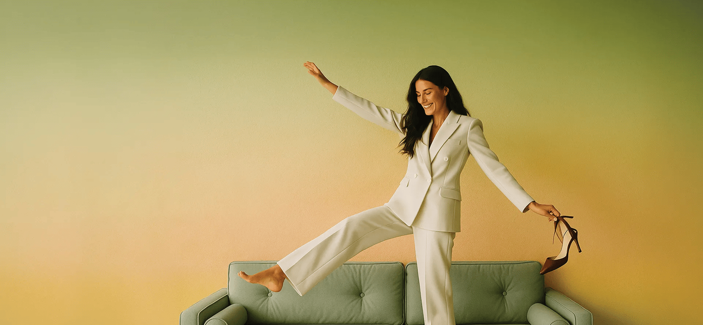 a woman in a white suit and heels is standing on a couch
