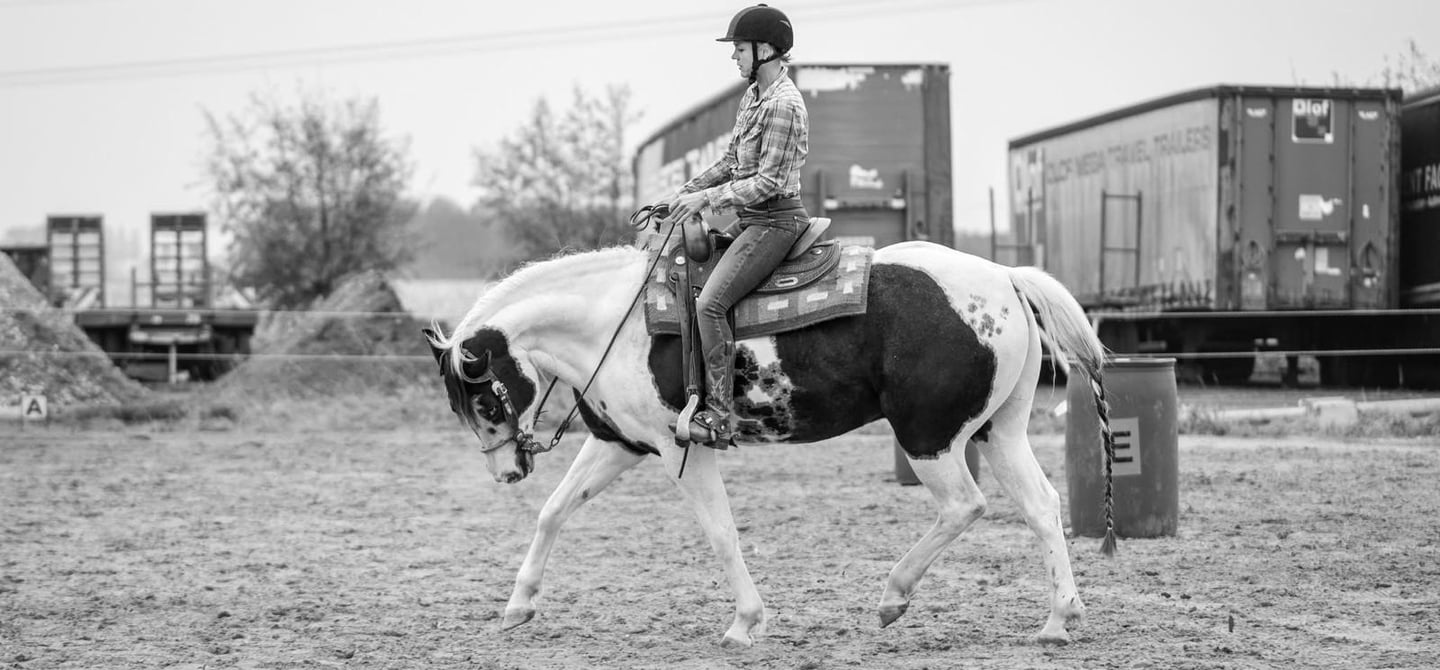 cowgirl die op haar paard rijdt
