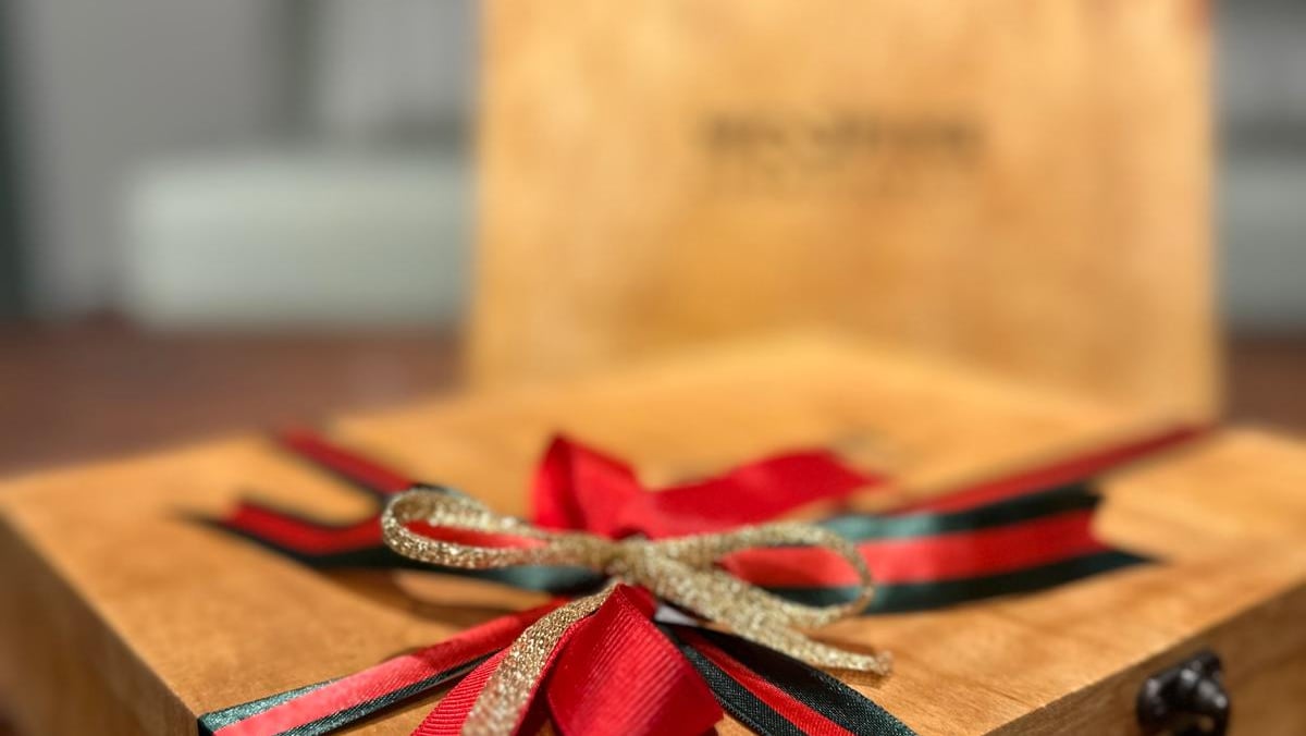 a wooden box with a red ribbon tied to it